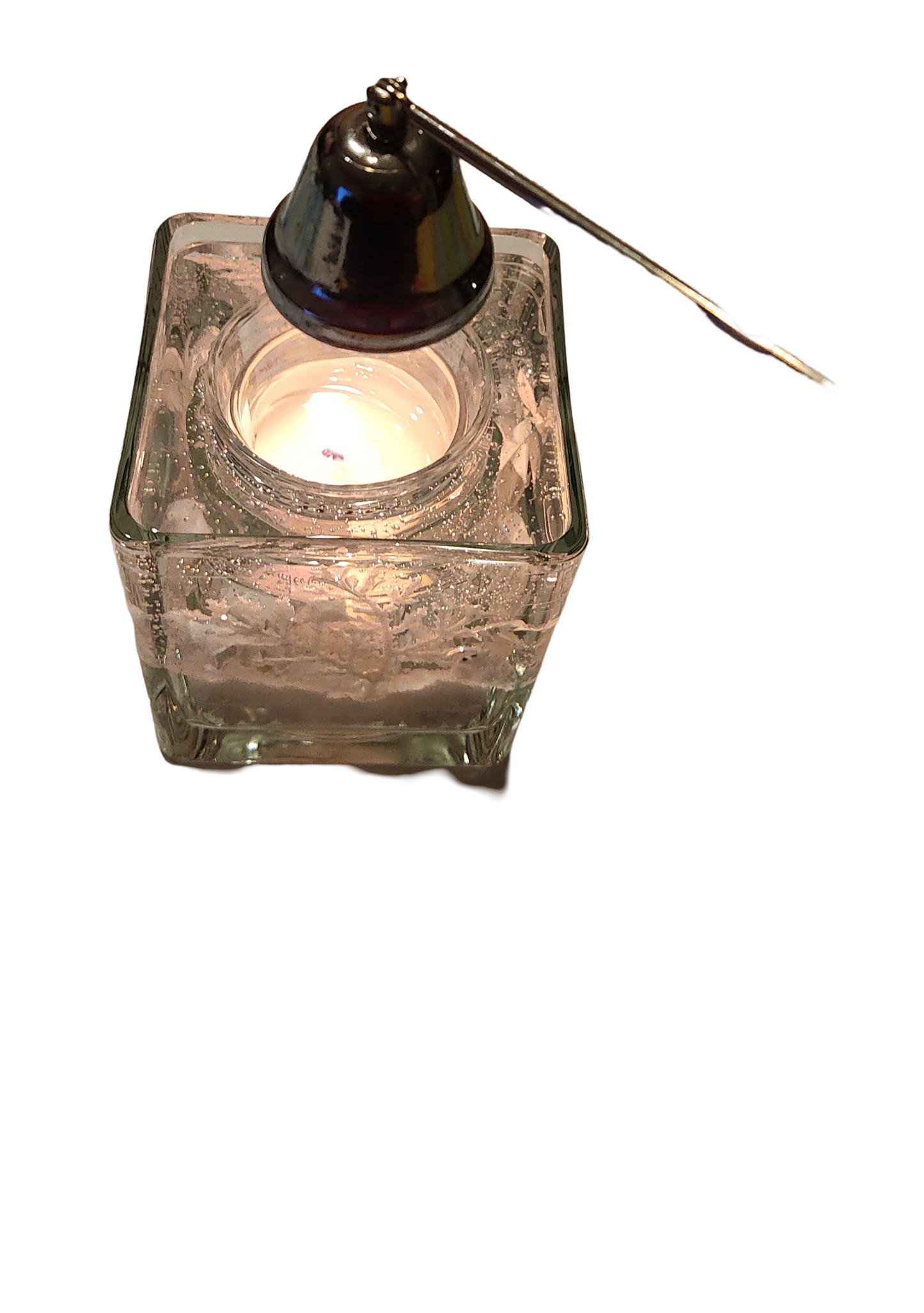 Bougeoir en verre carré avec un motif en relief, contenant une bougie allumée et un éteignoir en métal noir incliné sur le dessus
