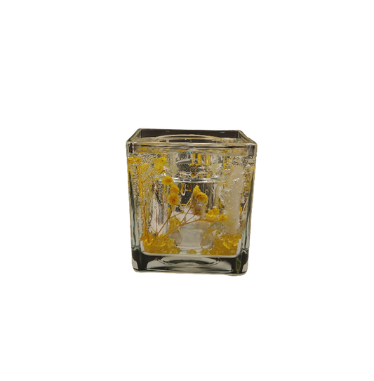 Photophore décoratif avec fleurs jaunes et gel scintillant, créant une ambiance chaleureuse.